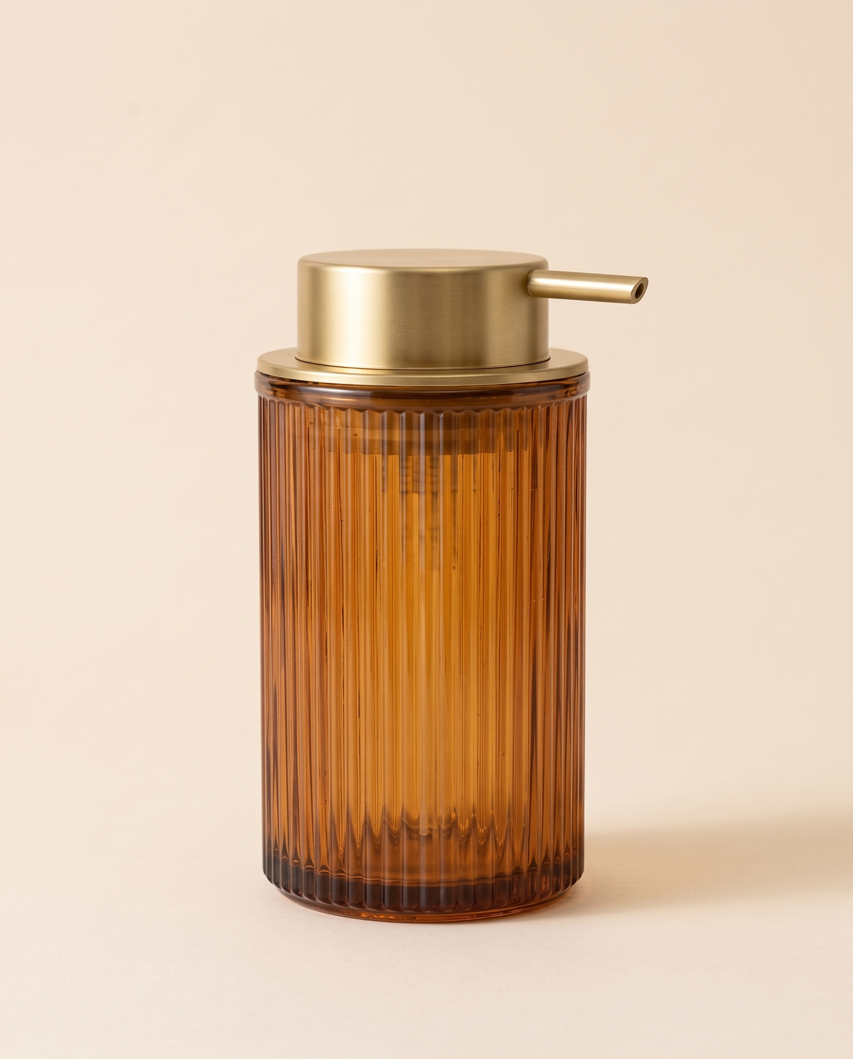 Ribbed amber glass foaming soap dispenser with a brushed gold pump