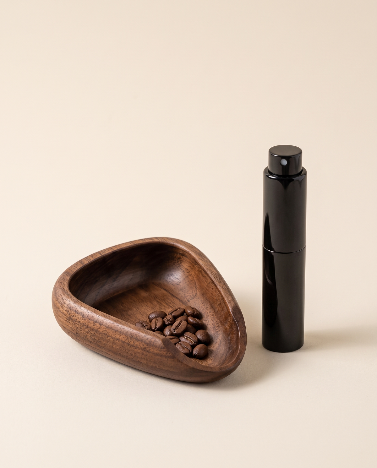 Walnut coffee dosing tray with coffee beans and a black spray bottle