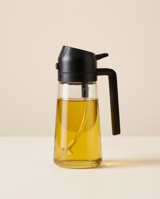 Glass oil sprayer with matte black cap on a cream background